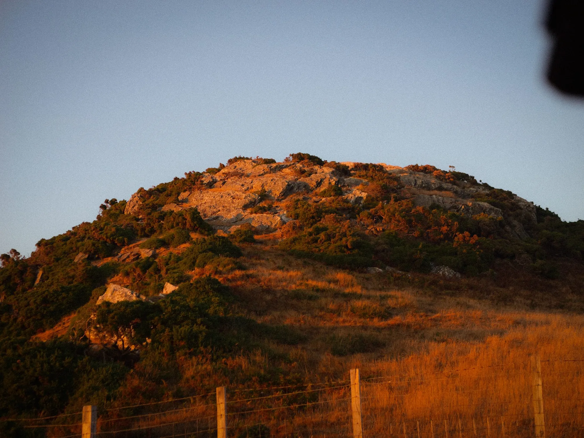A rocky hilltop catching the last warm light of the day