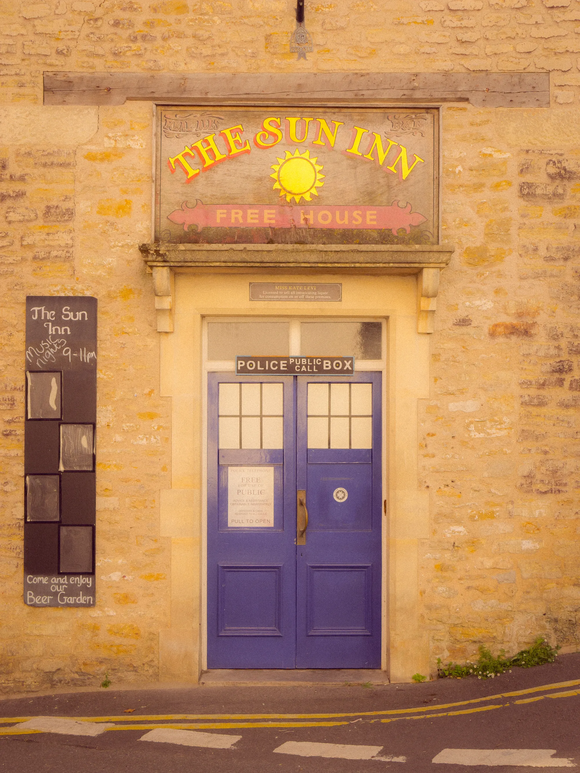 The Sun Inn doorway, blue doors in a honey stone front