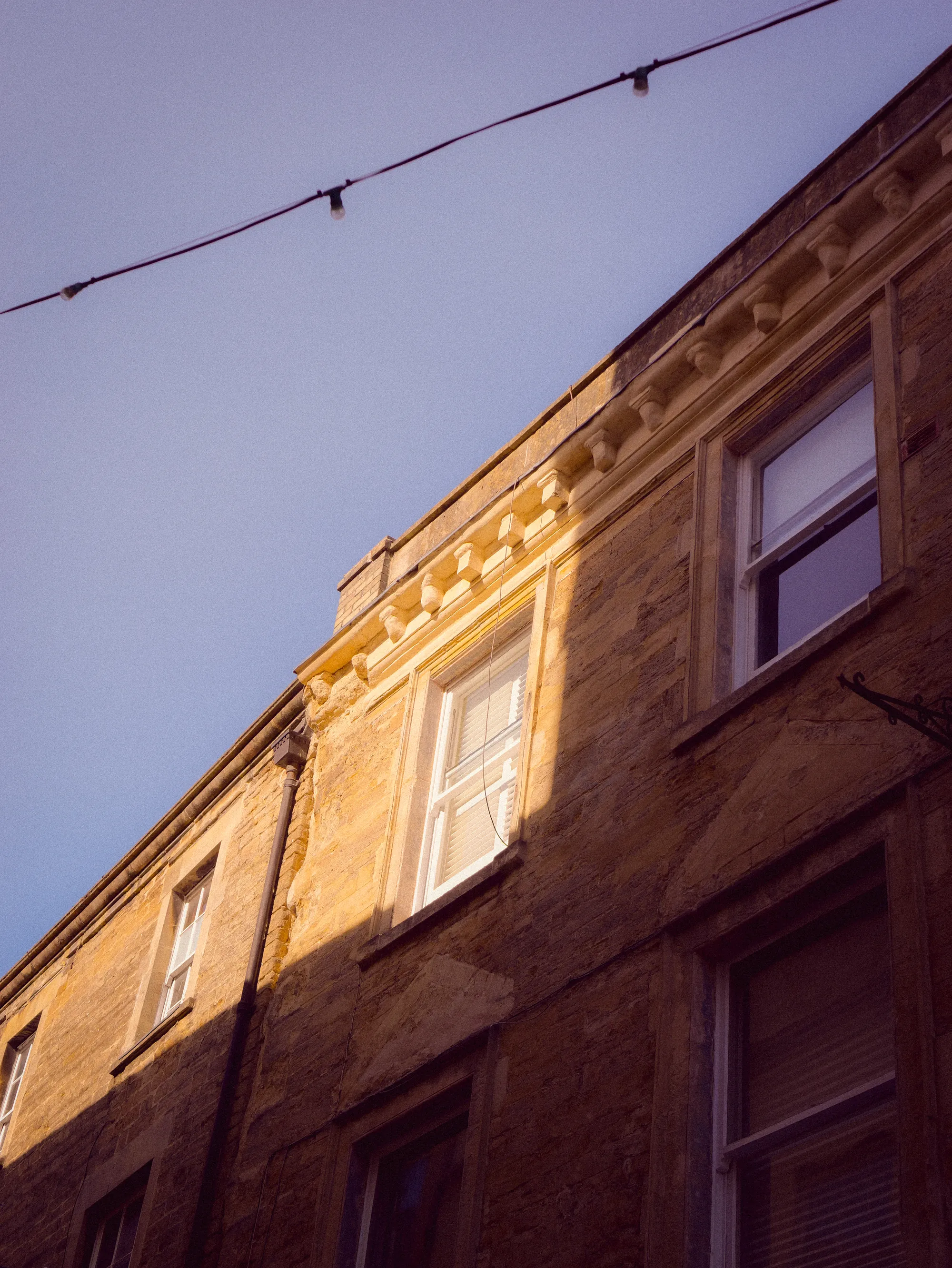 Looking up a stone terrace under a line of festoon lights