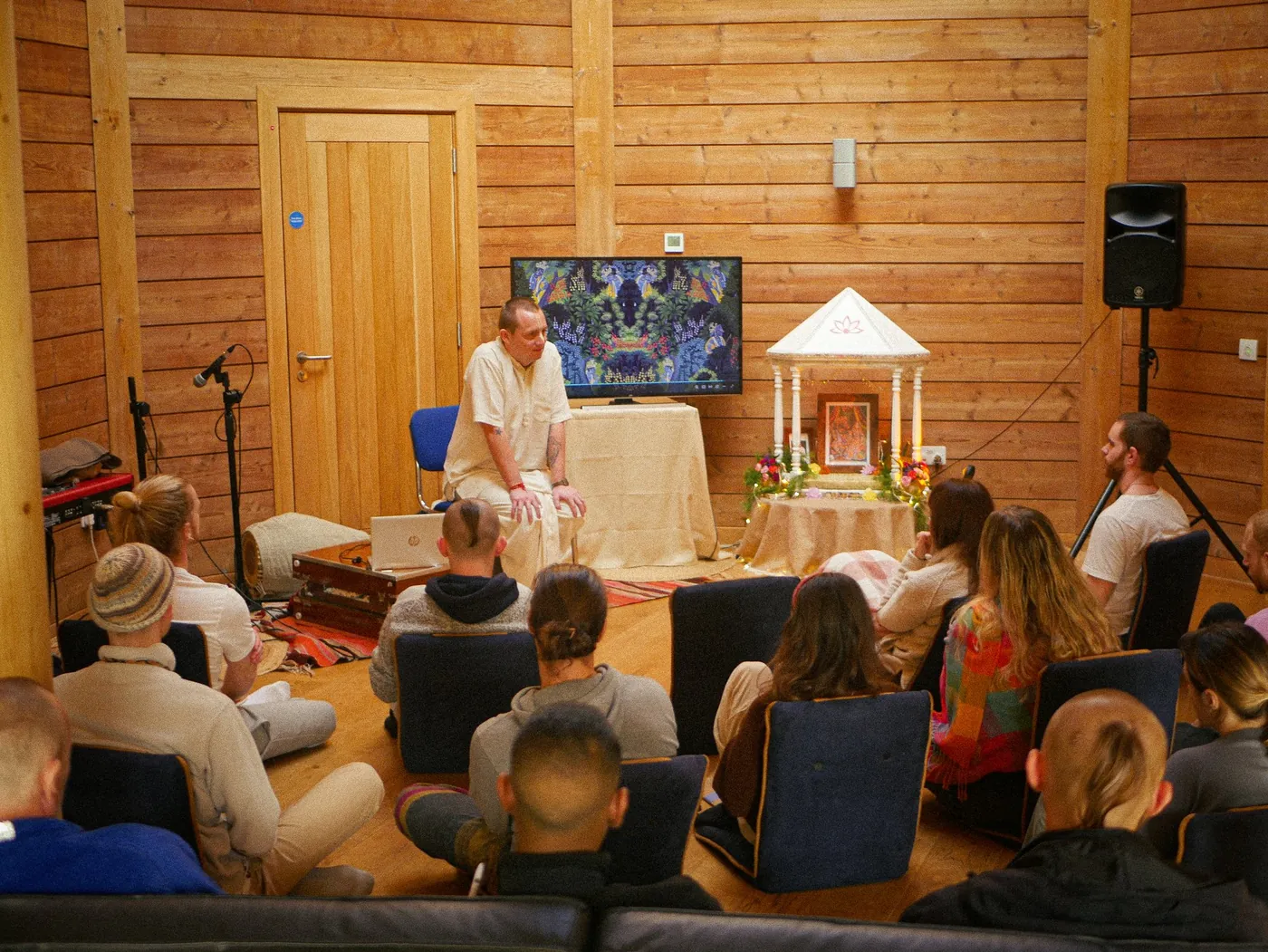 A gathering in the wooden hall at Tŷ Krishna Cymru